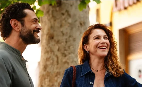 Un uomo e una donna sorridono ne Il Dio dell'amore